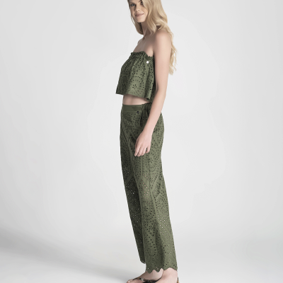 Conjunto feminino verde com padrão recortado a laser, top bandeau e calças, em modelo loira com sandálias pretas.