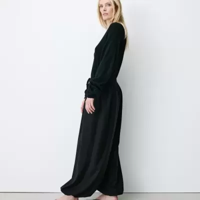 Mulher com vestido longo preto e mules pretas
