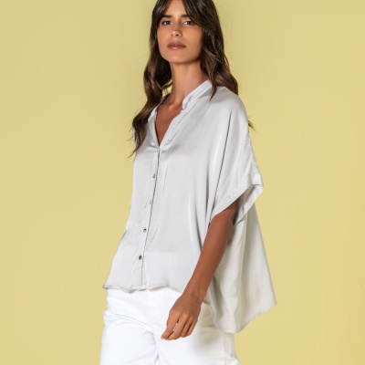 Modelo com blusa branca de tecido leve e calças brancas