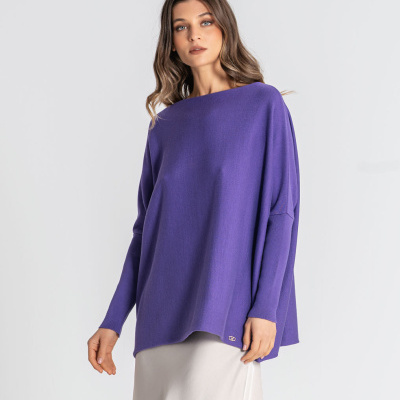 Modelo a usar camisola oversized roxa e saia bege clara com renda preta