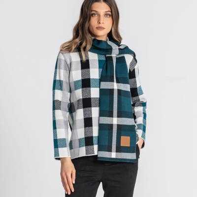 Mulher com camisola e cachecol xadrez e calças pretas