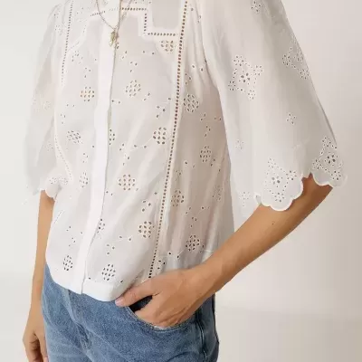 Blusa branca feminina bordada com mangas curtas e calças de ganga azuis
