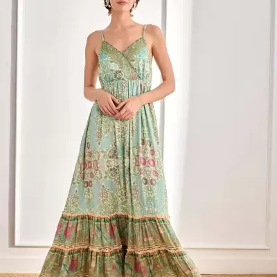 Vestido comprido floral verde e azul com folho na base usado por mulher