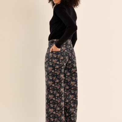 calças largas com padrão floral, camisola preta, sapatos pretos