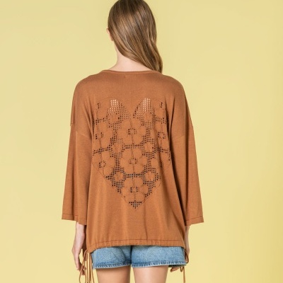 Camisola castanha de malha com padrão recortado nas costas e calções de ganga azuis