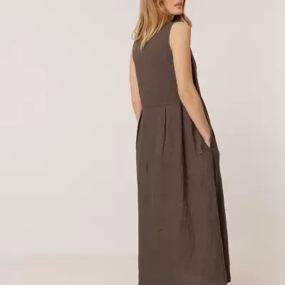 Mulher de costas a usar vestido comprido castanho escuro e sapatos rasos castanhos