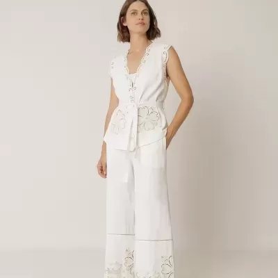 Conjunto feminino branco com bordados florais e sandálias marrons.