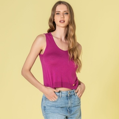 Top rosa magenta sem mangas com jeans azul claro em fundo amarelo claro