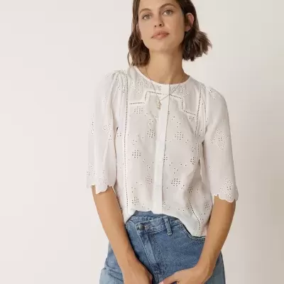 Blusa branca bordada feminina com mangas 3/4 e jeans azul claro.