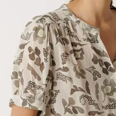 Blusa feminina com padrão floral em tons neutros e mangas curtas franzidas.