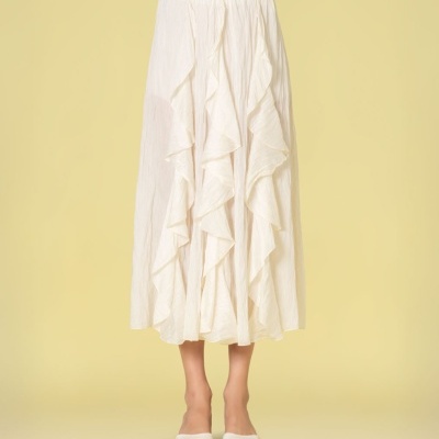 Saia comprida branca com folhos verticais e sandálias brancas