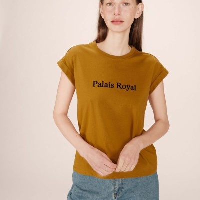 Camisola castanha com texto Palais Royal vestida por mulher e calças de ganga azuis