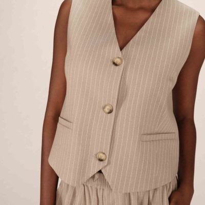 Colete bege com riscas finas brancas e botões, tecido liso.