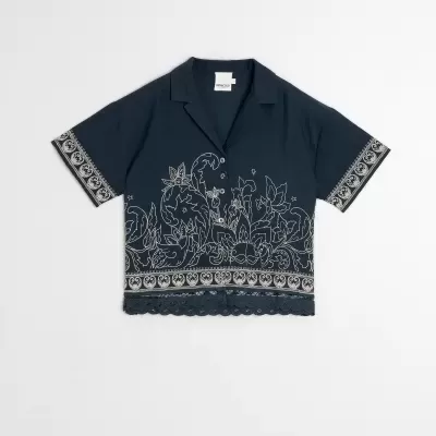Camisa curta azul escura com padrão floral branco e detalhes em renda na barra