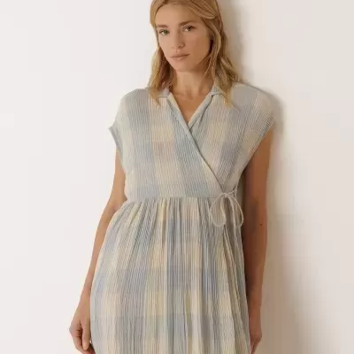 Vestido comprido azul claro e creme com padrão xadrez e amarração na cintura.