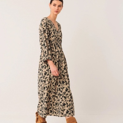 Vestido comprido floral bege e preto com botas castanhas de camurça.