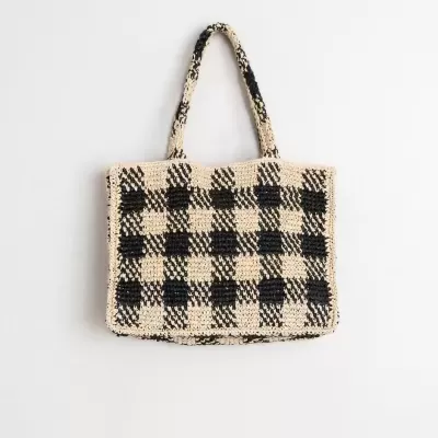 Bolsa de mão em tecido tricotado bege e preto com padrão xadrez e duas alças médias