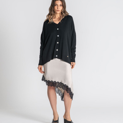 Mulher com cardigan preto e saia bege com renda preta