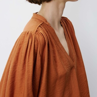 Blusa terracota com mangas franzidas e decote em V com fundo branco