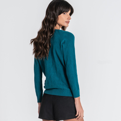 Mulher vista de costas com pull azul turquesa e calções pretos