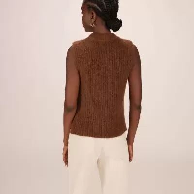 Regata castanha de malha felpuda e calças brancas vista de costas