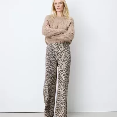 Mulher com camisola castanha de malha e calças com estampa animal