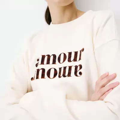 Sweatshirt creme com texto estampado em padrão animal print