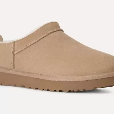 Pantufa tipo mule bege com sola castanha em fundo branco