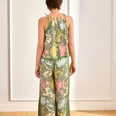 Conjunto feminino colorido com top de alças finas e calças largas com padrão paisley, visto de costas.