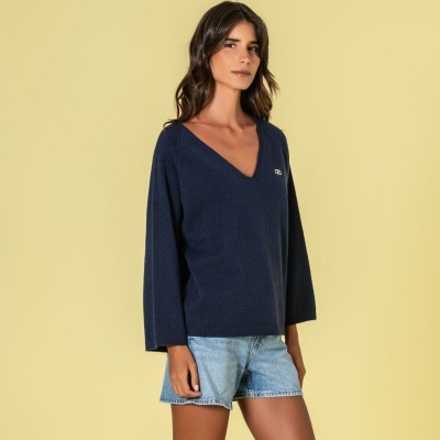 mulher com camisola azul escura e calções de ganga