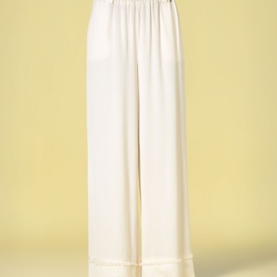 Calças largas brancas com cinto castanho e sandálias pretas