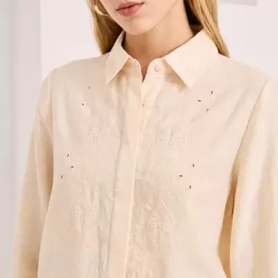 Camisa bege clara com bordado e cinto castanho com tachas douradas