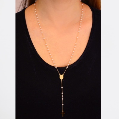 Colar de terço com pérolas e cruz dourada sobre camisola preta