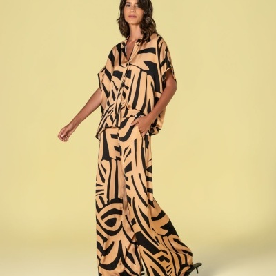 Conjunto feminino com blusa e calças largas com padrão abstrato preto em tecido bege