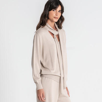 Conjunto feminino bege claro com blusa de mangas compridas e calças largas