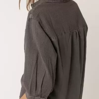 Camisa cinza escura texturizada de manga 3/4 com punhos abotoados, vista lateral de costas.