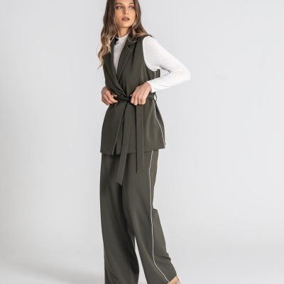Conjunto feminino verde com colete e calças largas e blusa branca, em fundo branco