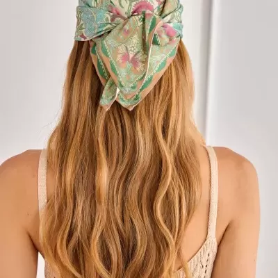 Lenço colorido com padrão floral usado na cabeça