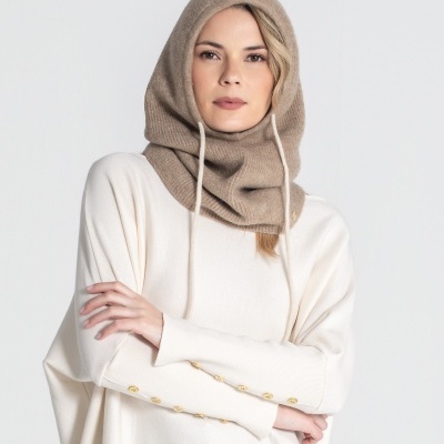 Mulher com capuz bege e camisola branca de malha