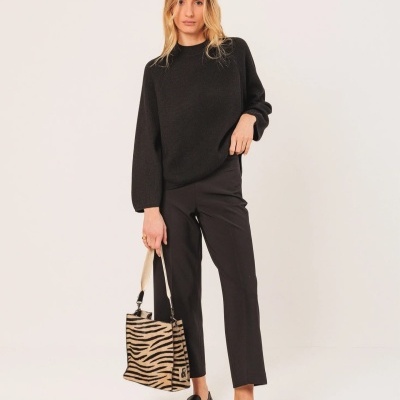 Mulher com roupa preta e mala com padrão de zebra