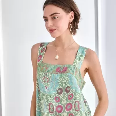 Top floral verde e azul com alças largas num modelo feminino