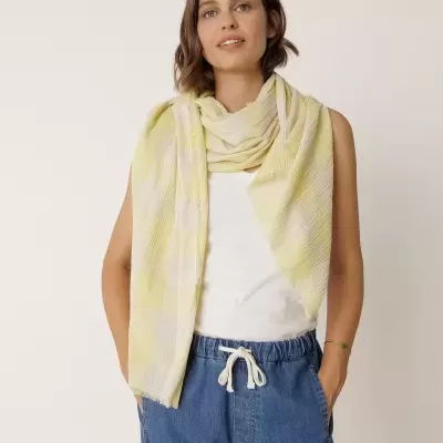 Lenço amarelo e branco de tecido leve com textura usado no pescoço