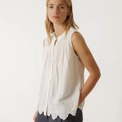 Blusa branca sem mangas com detalhes plissados e bordado inglês com calças riscas finas