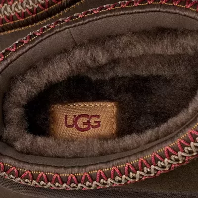 Interior de calçado castanho UGG com forro felpudo e costura decorativa