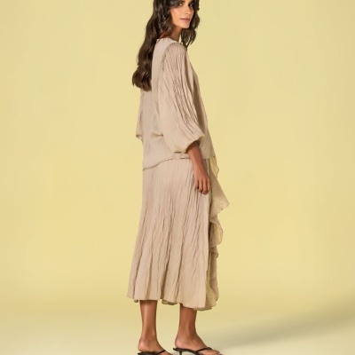 Conjunto feminino bege com blusa e saia midi texturizadas e sandálias de salto baixo pretas