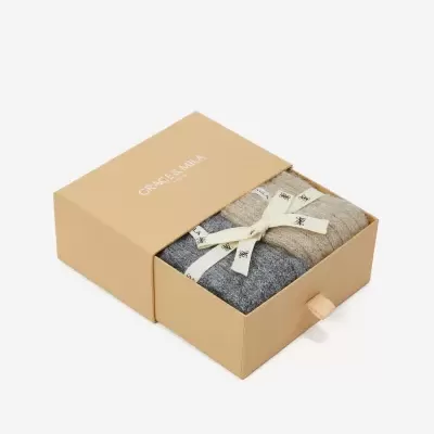 Conjunto de malhas em caixa bege com texto GRACE & MILA