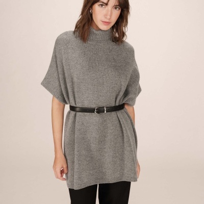 Mulher a usar túnica cinzenta de malha com cinto preto e calças pretas