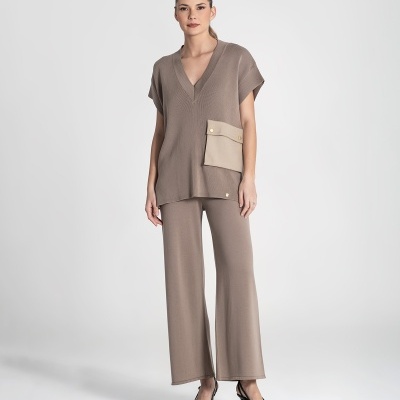 Mulher a usar conjunto feminino castanho com bolso bege e sapatos pretos, fundo branco.