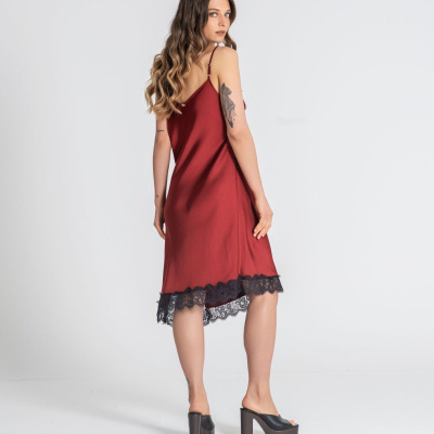 Vestido vermelho com renda preta na bainha usado por mulher com sapatos pretos de salto alto