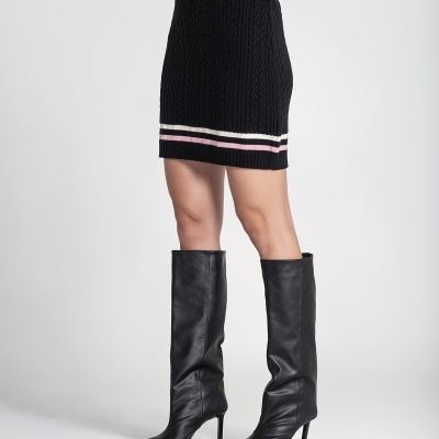 Saia preta em malha tricotada com detalhes brancos e rosa e botas pretas de salto alto